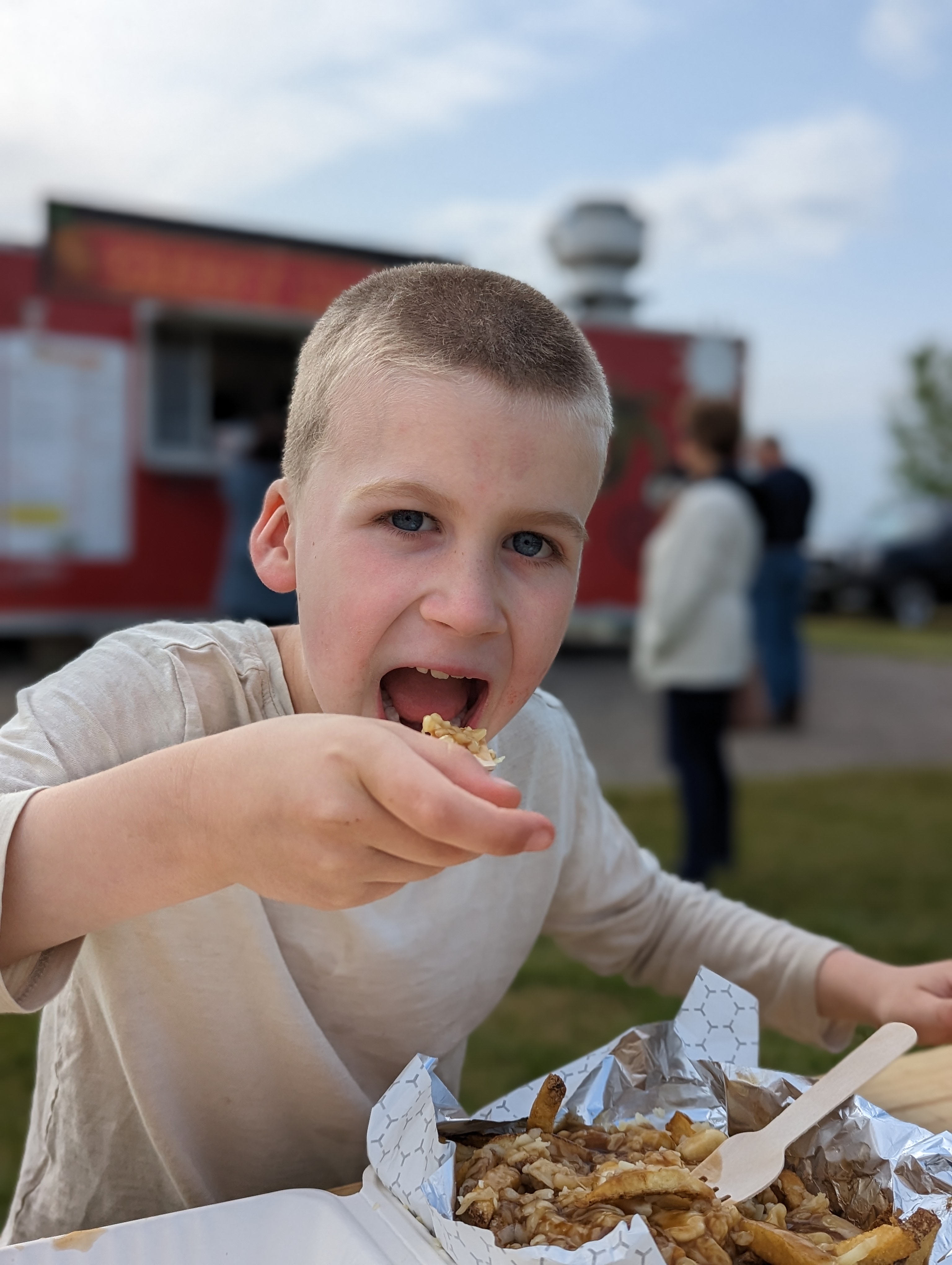 Cute kid eating poutine at the Cheesy Monkii Food Truck